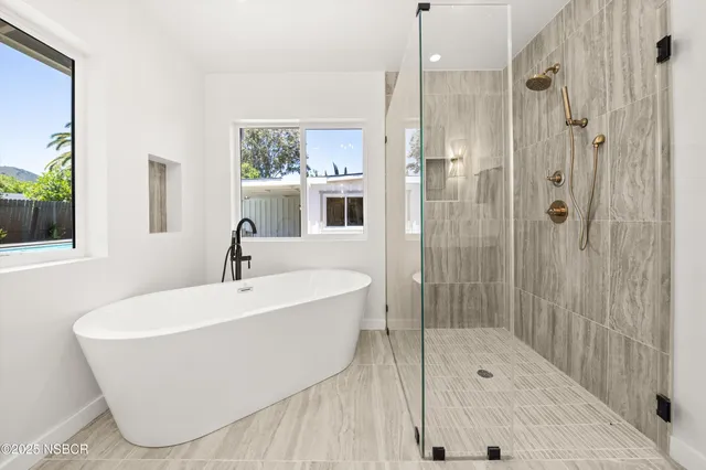 a bathroom with a white bath tub sitting next to a shower