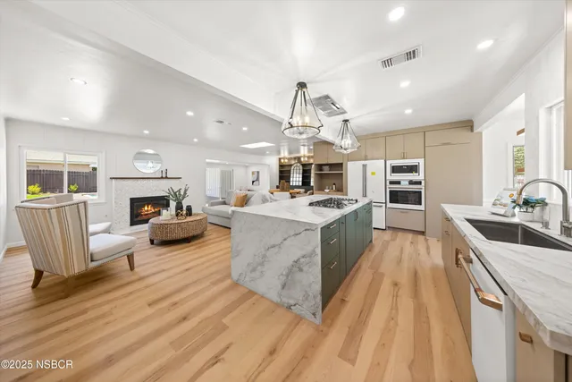 a large white kitchen with lots of counter space a sink and appliances