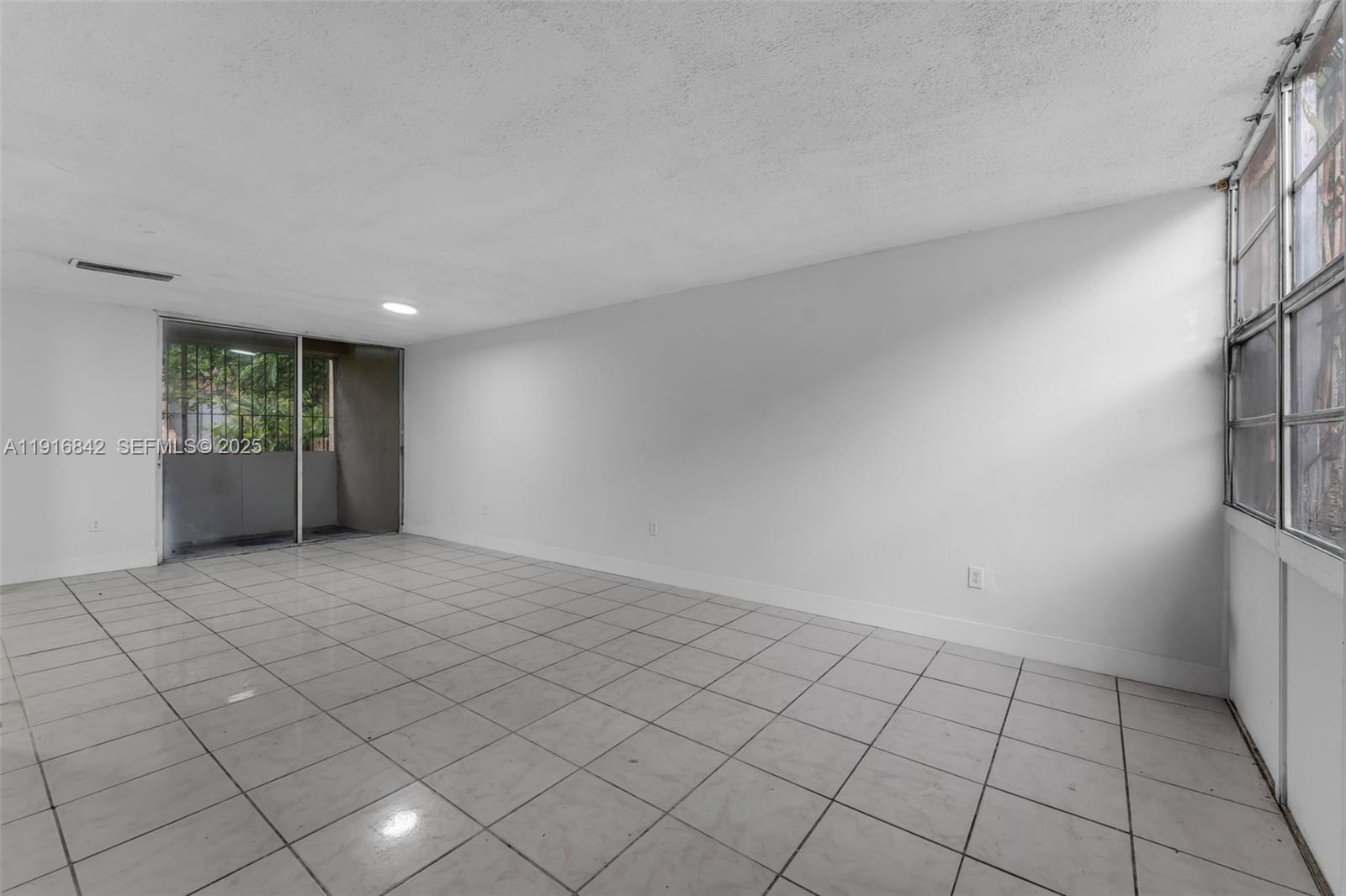 6011 Southwest 69th Street, Unit 72 South Miami, FL 33143 - Photo 4 of 22 a view of an empty room and window