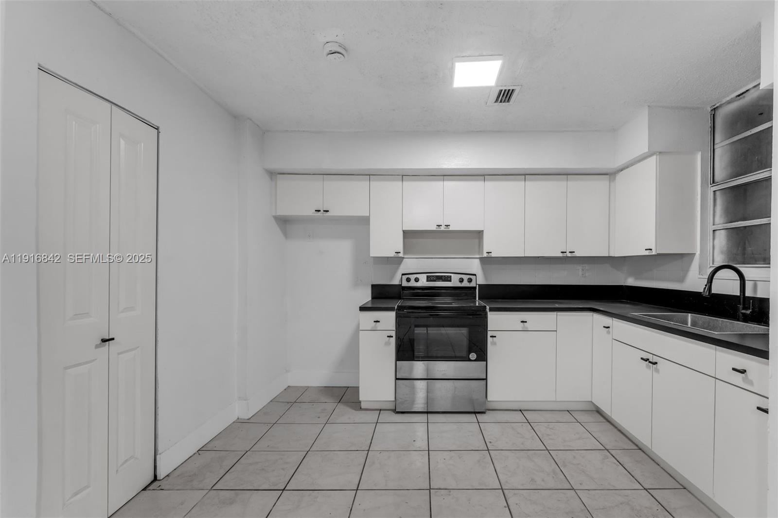 6011 Southwest 69th Street, Unit 72 South Miami, FL 33143 - Photo 6 of 22 a kitchen with a sink and a stove top oven