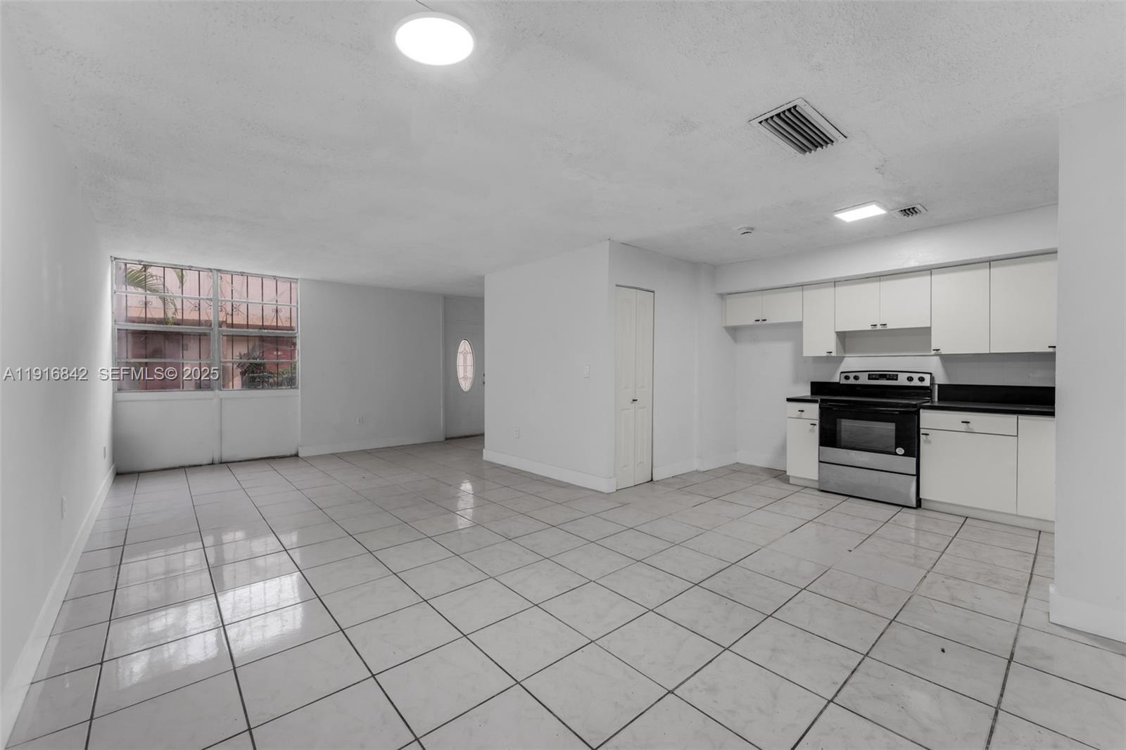 6011 Southwest 69th Street, Unit 72 South Miami, FL 33143 - Photo 8 of 22 a view of an empty room with a kitchen