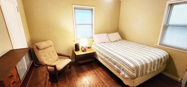 a bedroom with a bed chair and window
