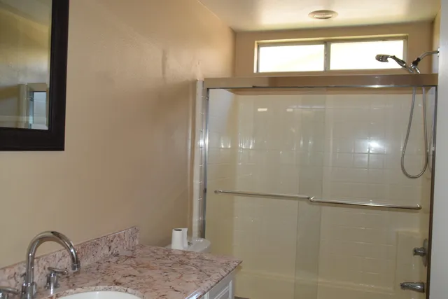 a bathroom with a granite countertop sink and a mirror