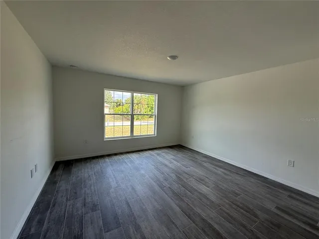 a view of an empty room with a window and a bathroom