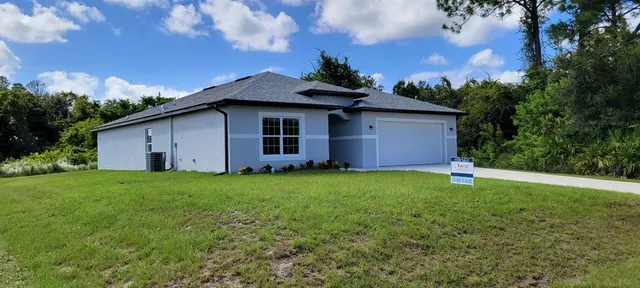 a view of a backyard with potted plants and a large tree
