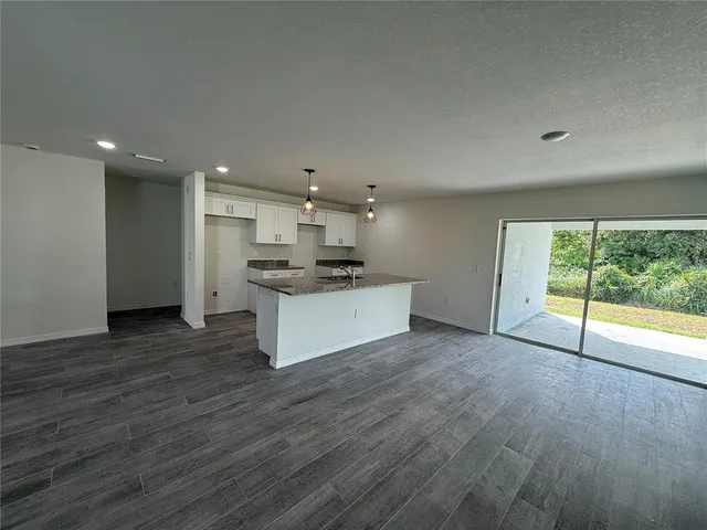 a view of a kitchen with a sink and dishwasher a refrigerator with wooden floor