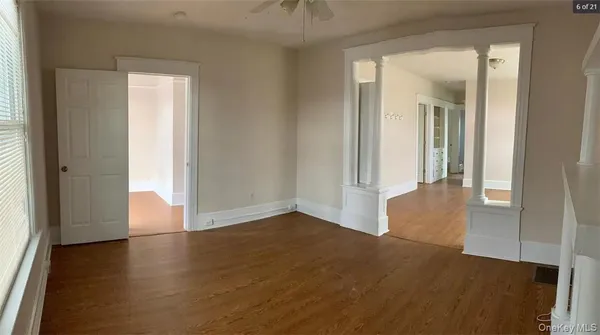 an empty room with wooden floor and a window