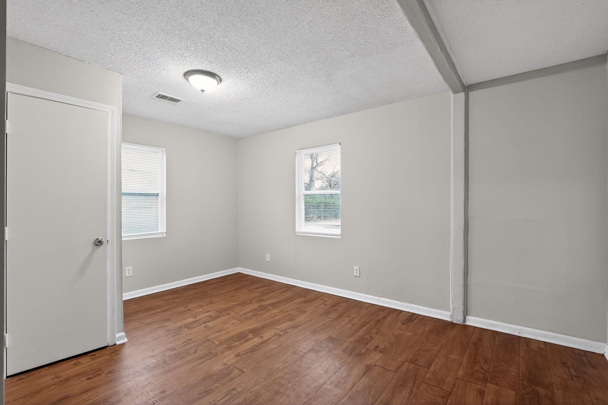 4314 Ford Road Memphis, TN 38109 - Photo 12 of 31 an empty room with wooden floor and windows