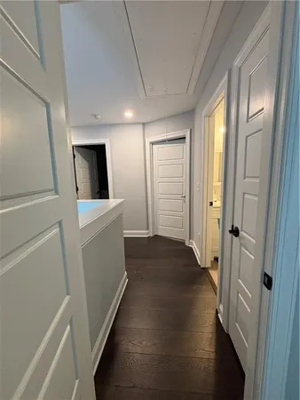 a view of a hallway with bathroom and wooden floor