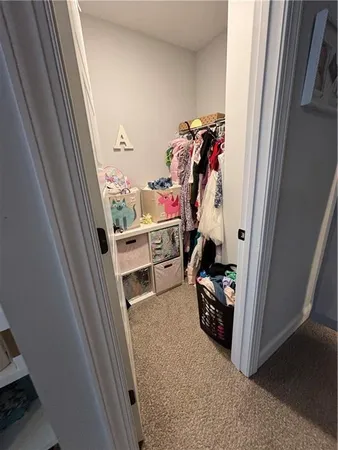 a view of walk in closet with clothes and shoes