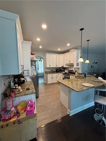 a kitchen with kitchen island granite countertop wooden cabinets and a sink