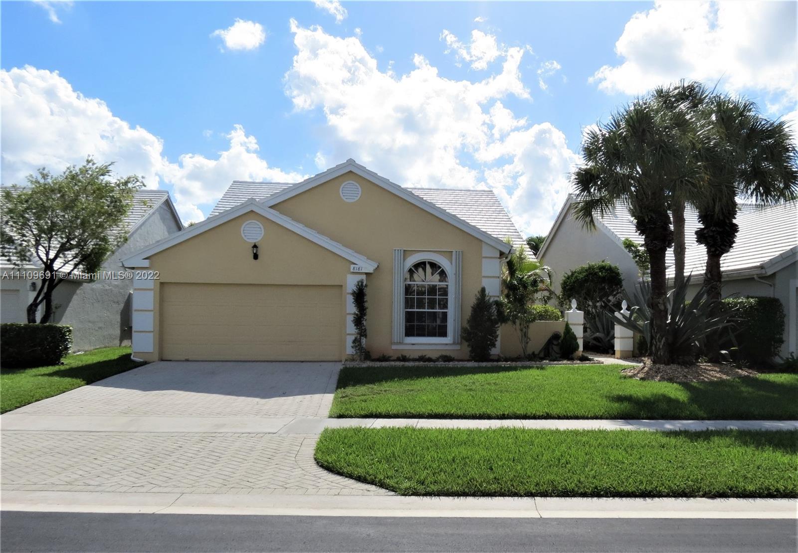 8181 Horseshoe Bay Road Boynton Beach, FL 33472 - Photo 1 of 41 a front view of a house with a garden and trees
