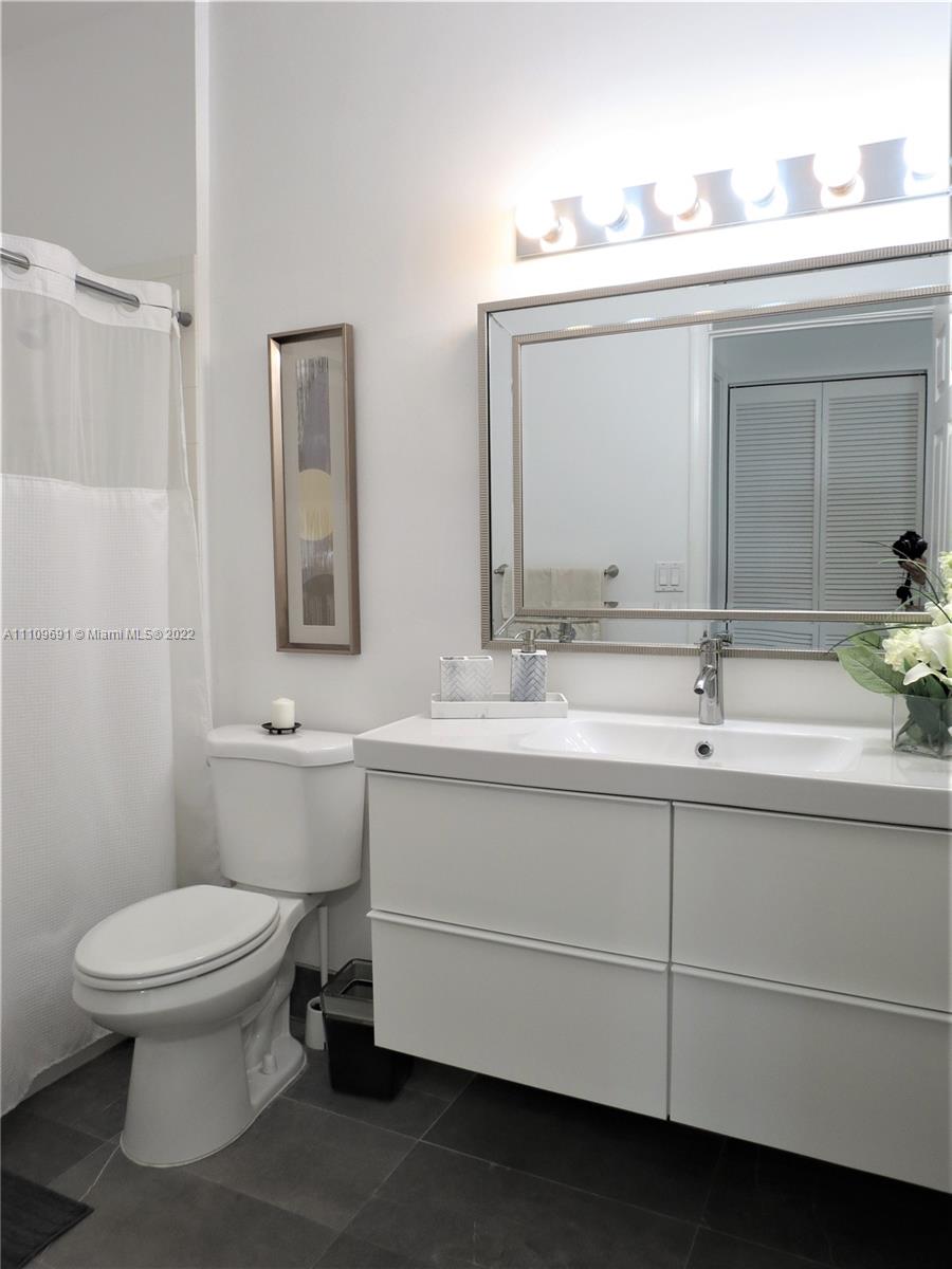 8181 Horseshoe Bay Road Boynton Beach, FL 33472 - Photo 22 of 41 a bathroom with a toilet sink and mirror
