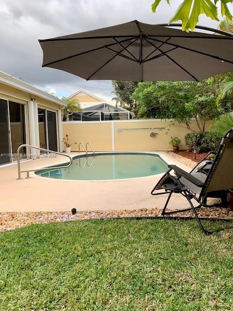 8181 Horseshoe Bay Road Boynton Beach, FL 33472 - Photo 28 of 41 a view of a backyard with table and chairs under an umbrella