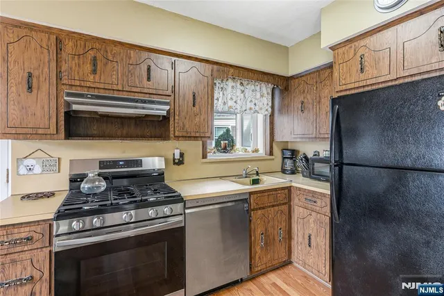 a kitchen with stainless steel appliances a stove a sink and a refrigerator
