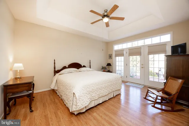 a bedroom with a bed a chair and a large window