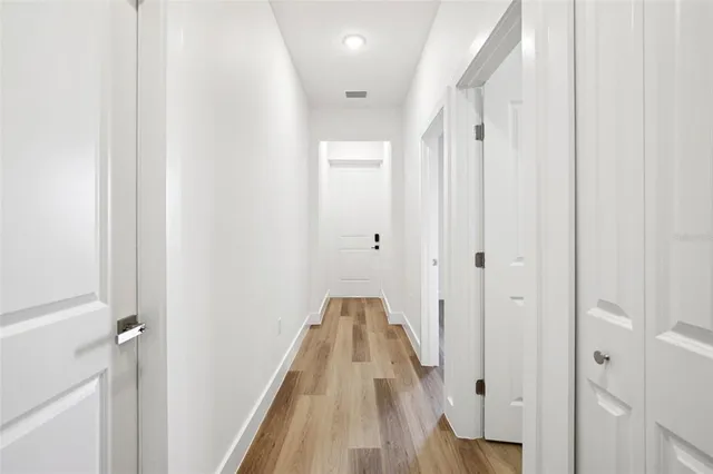 a view of a hallway with wooden floor and staircase