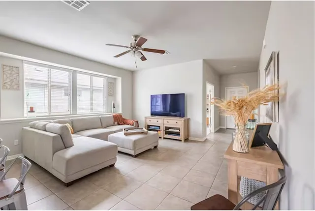 a living room with furniture a flat screen tv and a window