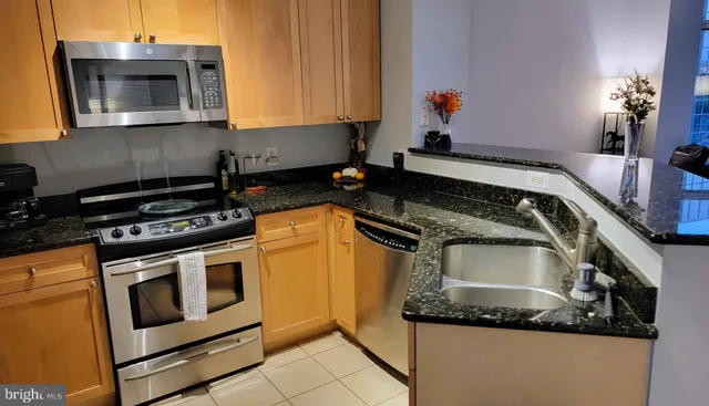 a kitchen with stainless steel appliances granite countertop a stove microwave and sink