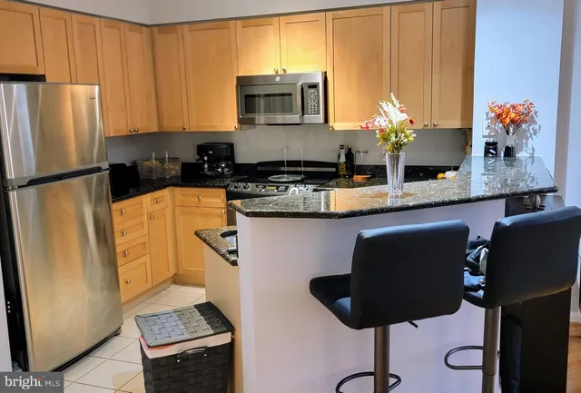 a kitchen with stainless steel appliances granite countertop a refrigerator sink and microwave