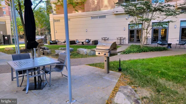a view of a patio with table and chairs and a large tree