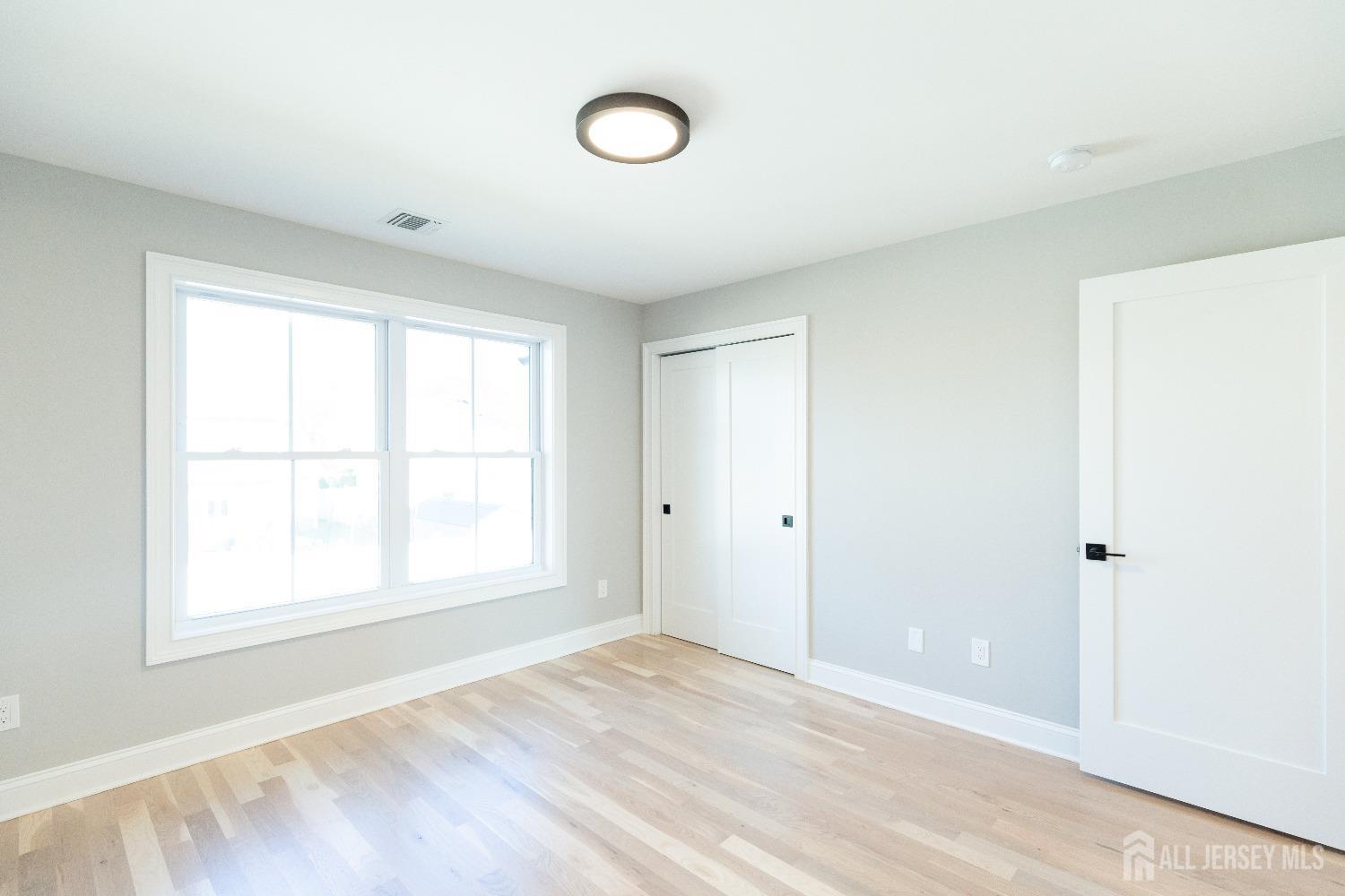 24 Parkerson Road Edison, NJ 08817 - Photo 44 of 56 a view of an empty room with wooden floor and a window