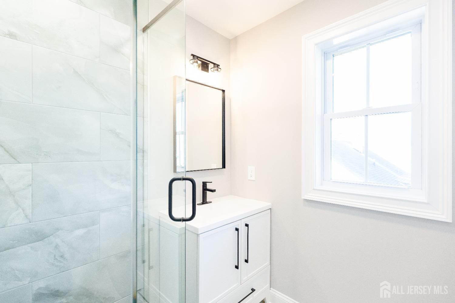 24 Parkerson Road Edison, NJ 08817 - Photo 46 of 56 a bathroom with a shower sink and mirror