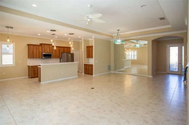 an empty room with kitchen and windows