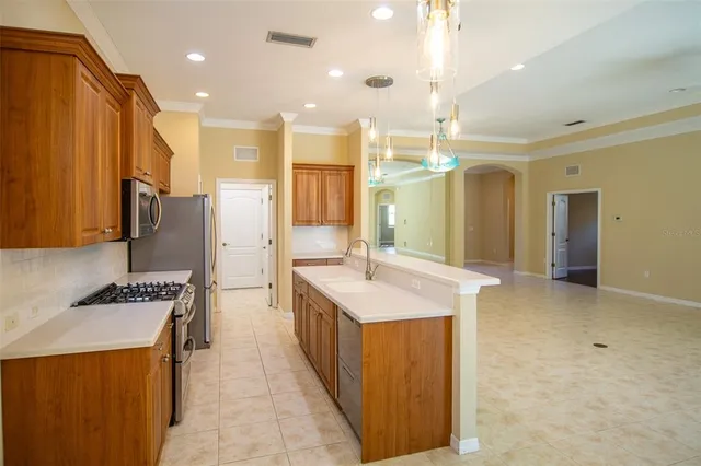 a kitchen with stainless steel appliances kitchen island a sink stove and refrigerator