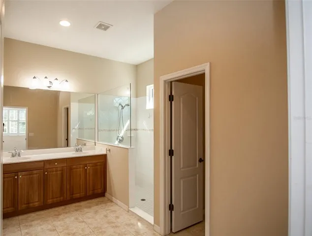 a bathroom with a double vanity sink mirror and shower