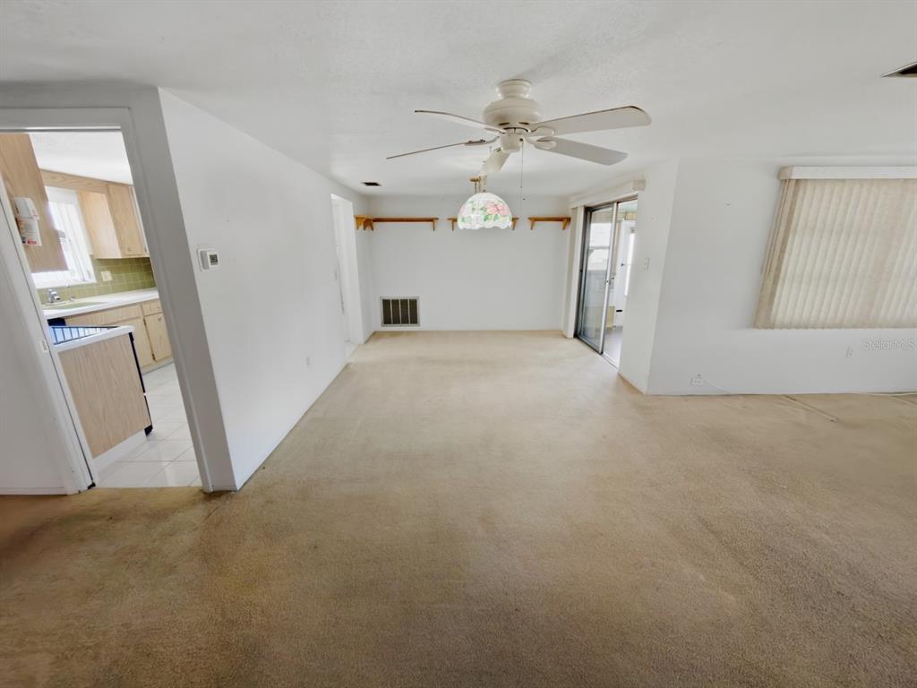 7903 Valmy Lane Port Richey, FL 34668 - Photo 16 of 40 en empty room with windows and ceiling fan