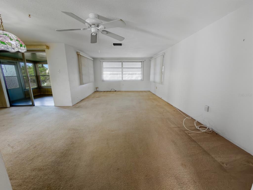 7903 Valmy Lane Port Richey, FL 34668 - Photo 17 of 40 en empty room with windows and ceiling fan