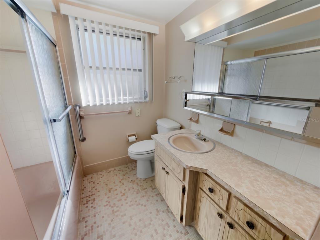 7903 Valmy Lane Port Richey, FL 34668 - Photo 26 of 40 a bathroom with a granite countertop sink a toilet and a shower a mirror