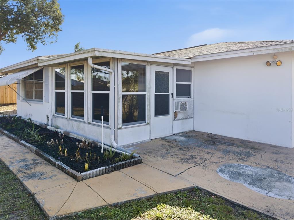 7903 Valmy Lane Port Richey, FL 34668 - Photo 31 of 40 a front view of a house with a garden