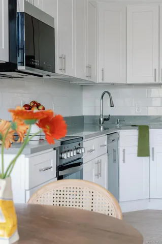 a kitchen with stainless steel appliances kitchen island sink stove and cabinets