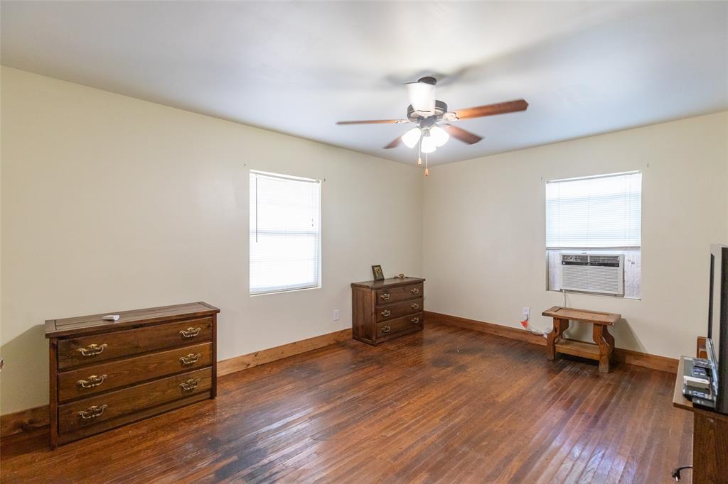 640 Ground Street Moran, TX 76464 - Photo 20 of 35 Spacious interior featuring wood-finish flooring, light-toned walls, and a ceiling fan with integrated lighting