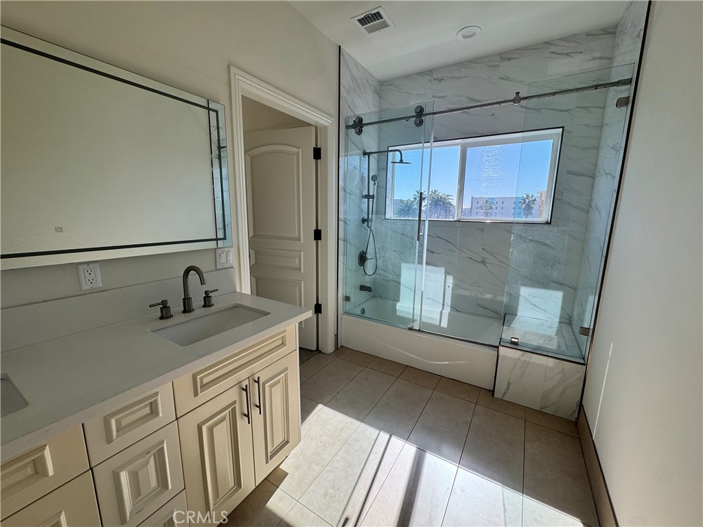 1598 Long Beach Long Beach, CA 90813 - Photo 5 of 6 a bathroom with a granite countertop sink a mirror and a shower