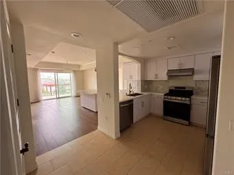 a kitchen with a refrigerator and a stove top oven
