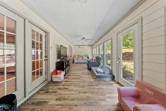a view of living room filled with furniture and large windows
