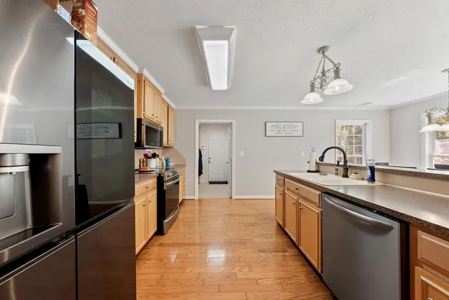 a kitchen with stainless steel appliances granite countertop a sink and refrigerator
