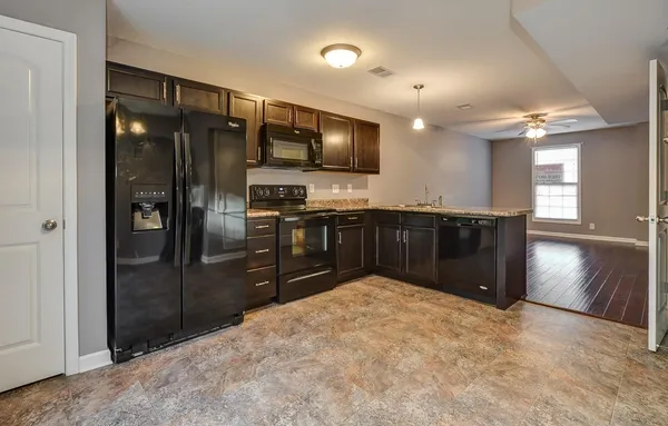 a kitchen with stainless steel appliances granite countertop a refrigerator and a sink