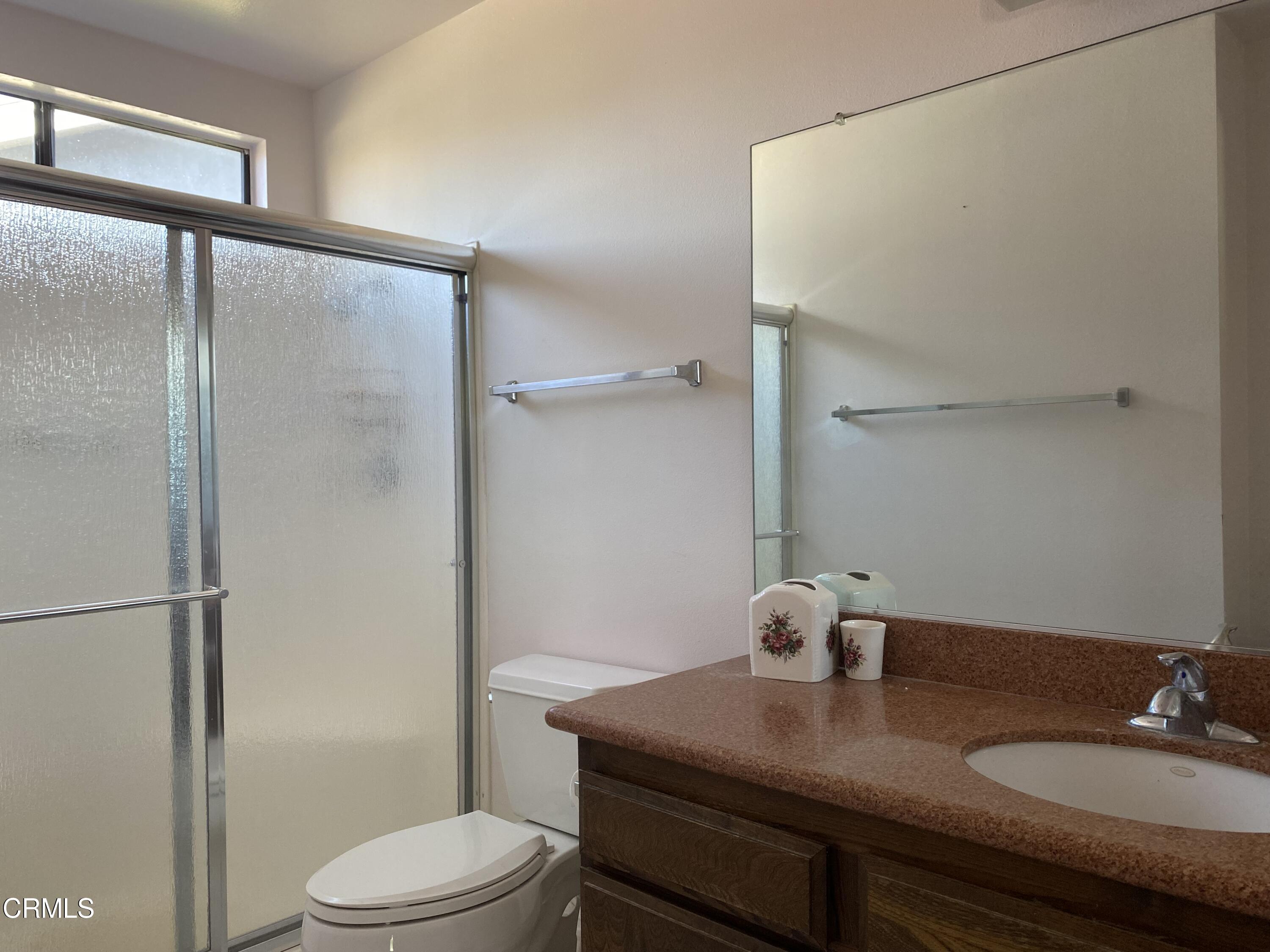 1341 Bottlebrush Place Oxnard, CA 93030 - Photo 17 of 25 a bathroom with a granite countertop sink toilet a mirror and shower