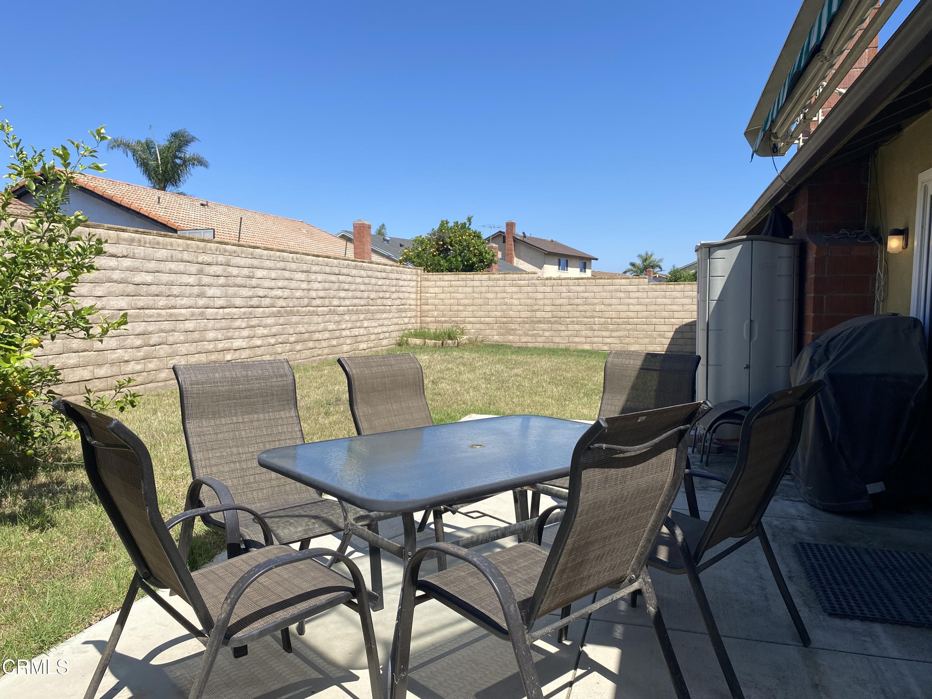 1341 Bottlebrush Place Oxnard, CA 93030 - Photo 22 of 25 a view of a patio with table and chairs with wooden floor and fence
