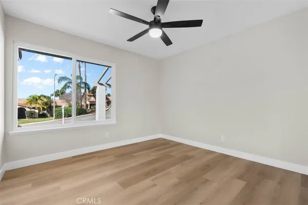 a view of a big room with wooden floor and a window