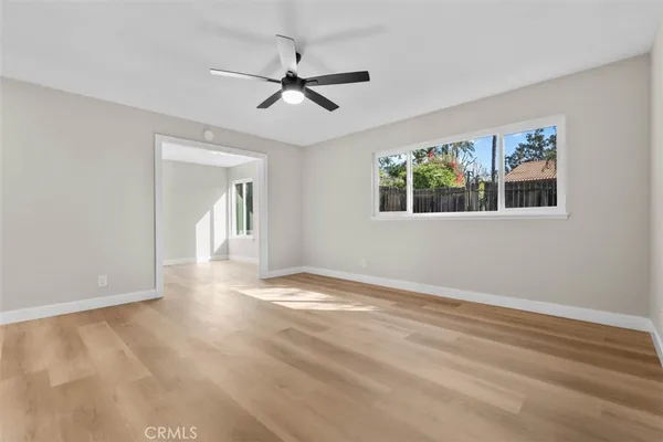 a view of empty room with window and ceiling fan