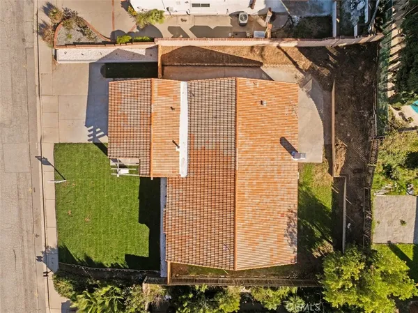 an aerial view of a house with a garden and trees