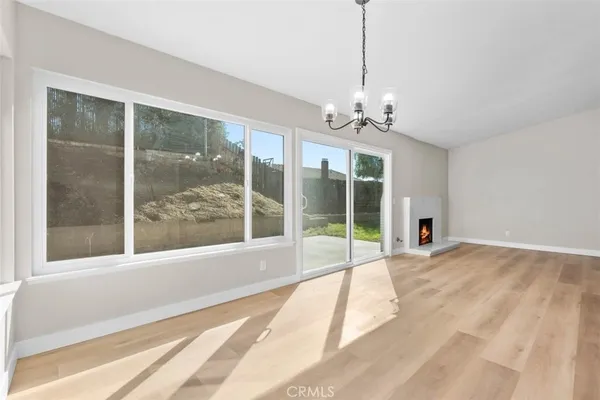 a view of an empty room with windows and a chandelier