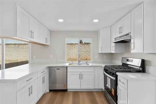 a kitchen with cabinets appliances a sink and a window