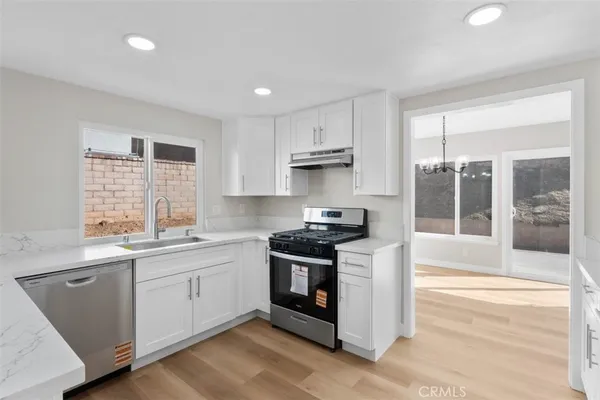 a kitchen with stainless steel appliances granite countertop a stove a sink and a microwave