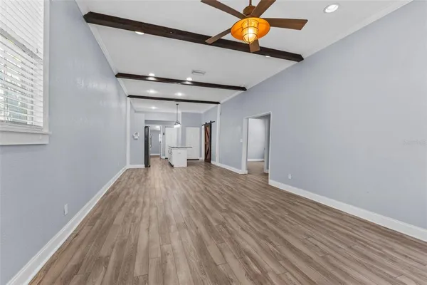 a view of empty room with wooden floor